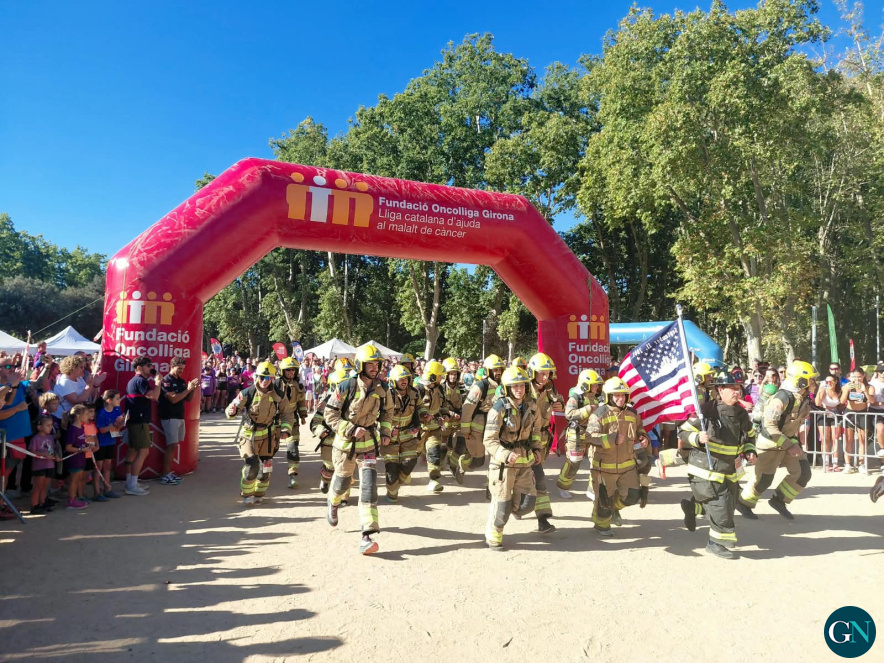 alt - Sortida dels bombers i bomberes que han participat a la cursa d'aquest matí, equipats amb els EPI, d'uns 20 kg de pes 